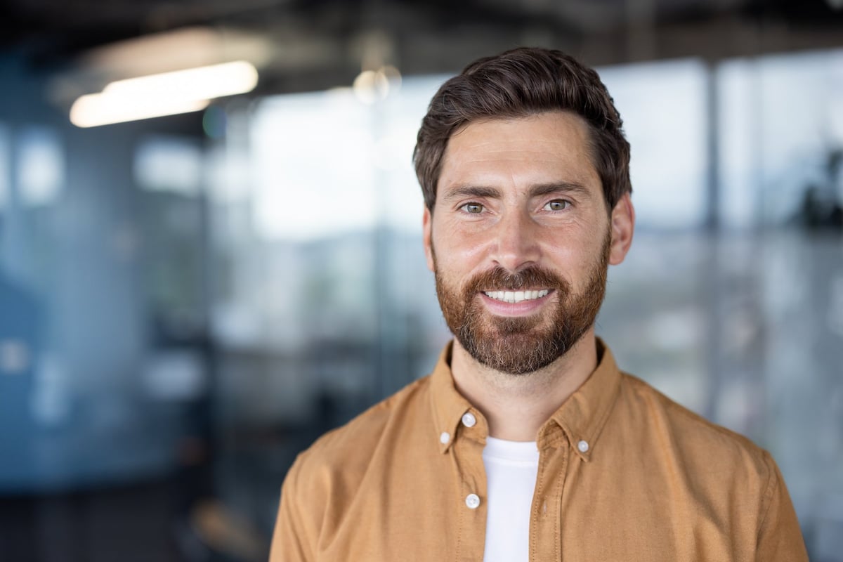 Confident bearded man smiling at the camera, wearing a casual shirt