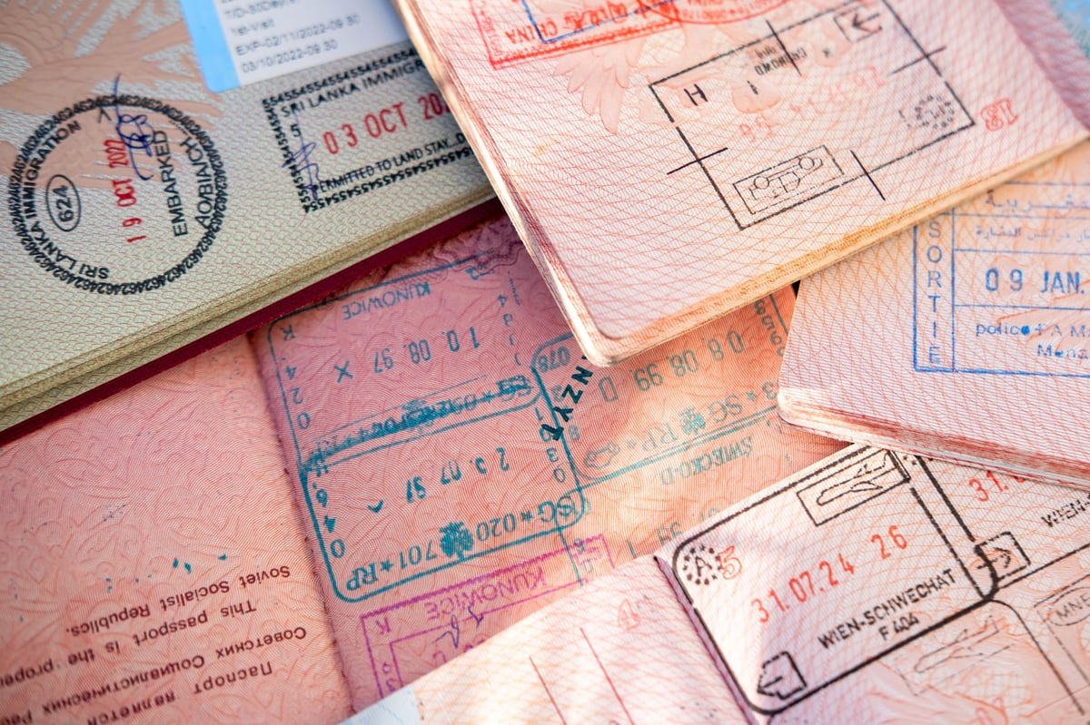 overlapping pages reveal stamps, colorful entry exit stamps, international travel, border control, identity verification