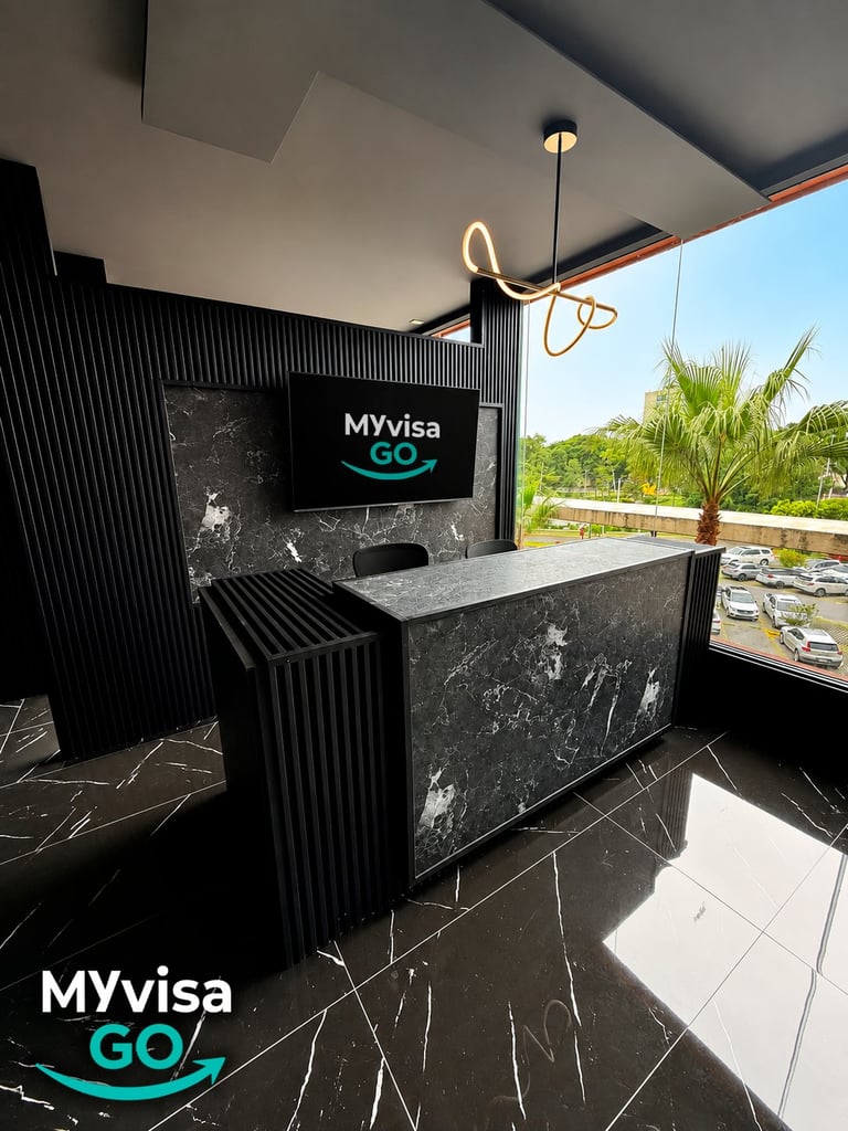 Área de recepción de las instalaciones de MyVisaGo con mostrador de mármol oscuro y pantalla de marca