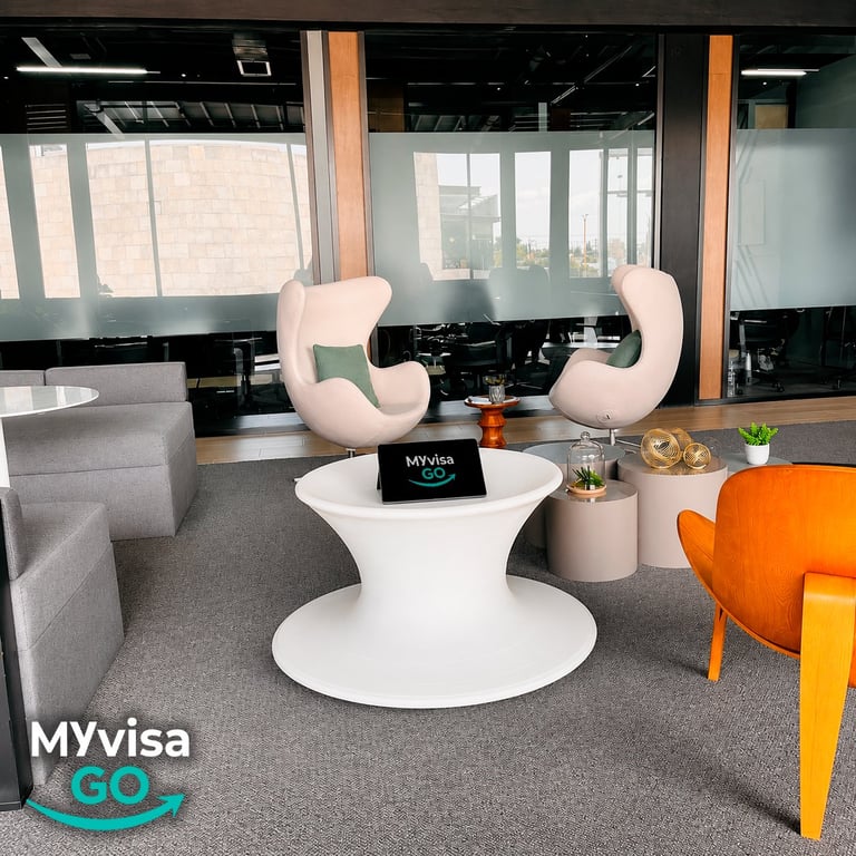 Área de espera y lounge de las oficinas de MyVisaGo con sillones y ventanales con vista a la ciudad